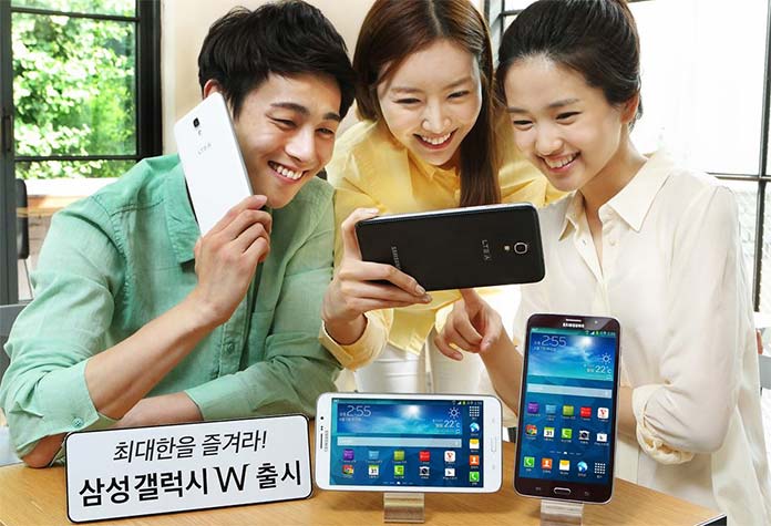 Photograph showing three people operating phablets.